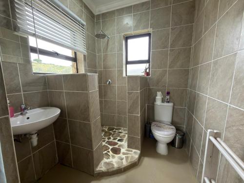 a bathroom with a toilet and a sink at Shama Lodge - "Silent Sunsets" Duplex Cottage in Steytlerville