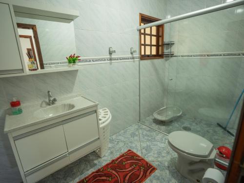 a bathroom with a toilet and a sink and a shower at Chácara Pimenta Vermelha in Socorro
