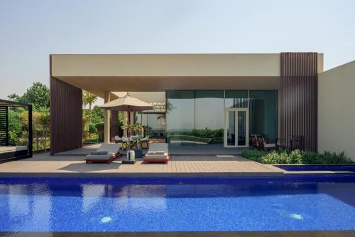 a house with a swimming pool next to a house at Al Zorah Beach Resort in Ajman 