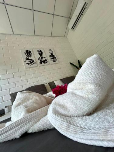 a room with two towels and a flower on a bed at Ima House in Ahangama