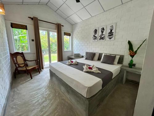 a bedroom with a large bed with flowers on it at Ima House in Ahangama