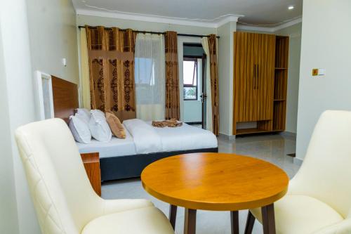 a hotel room with a bed and a table and chairs at Hotel Amani Limited in Mwana Island