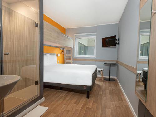 a bedroom with a bed and a sink and a bathroom at ibis budget Lima Miraflores in Lima