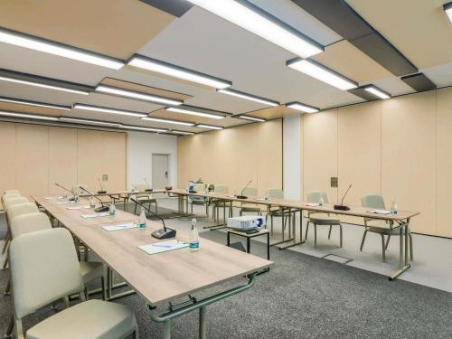 a large room with tables and chairs with computers on them at ibis Timisoara City Center in Timişoara