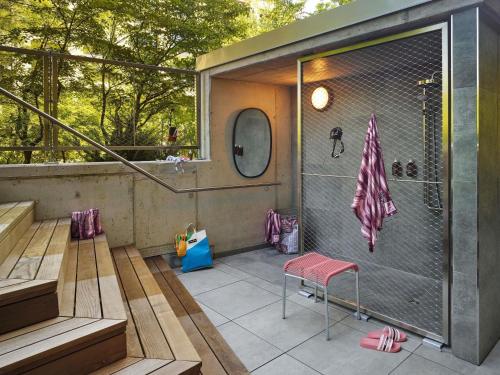 a small house with a balcony with stairs and a pink stool at 25hours Hotel Zürich West in Zurich