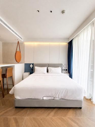 a bedroom with a large white bed and a table at Studio Apartment by Sunshine Beach in Layan Beach