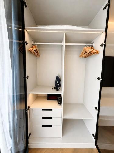 a walk in closet with white shelves and a shower at Studio Apartment by Sunshine Beach in Layan Beach
