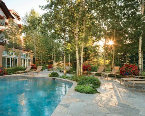 a swimming pool in a yard with benches and trees at Sonnenalp in Vail