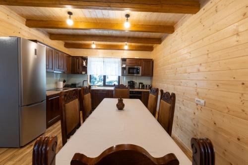 a kitchen with a table and a refrigerator at Cabana Magura Mare Belis in Călăţele