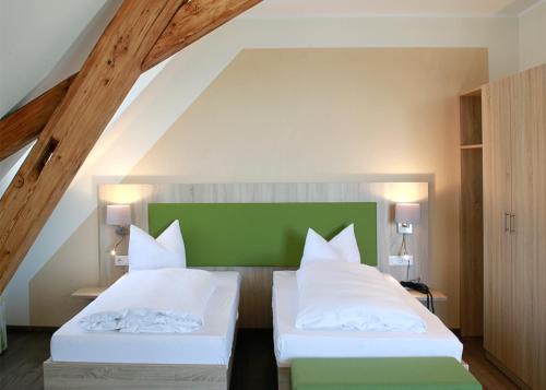 a bedroom with two beds and a green headboard at Schwarzwald Apartments Fürstenberg in Hüfingen