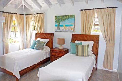 2 camas en una habitación con 2 ventanas en ZenBreak Silver Sands Villa 1, en Christ Church