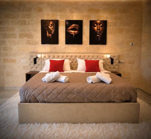 a bedroom with a large bed with three pictures on the wall at Aphrodeseum Romantic Suite in Taranto