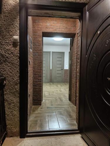 a hallway with a mirror and a brick wall at Шепіт Річки in Mizhhirya