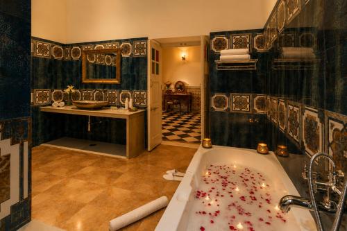 a bathroom with a tub with candles in it at WelcomHeritage Mohangarh Fort in Sodākor