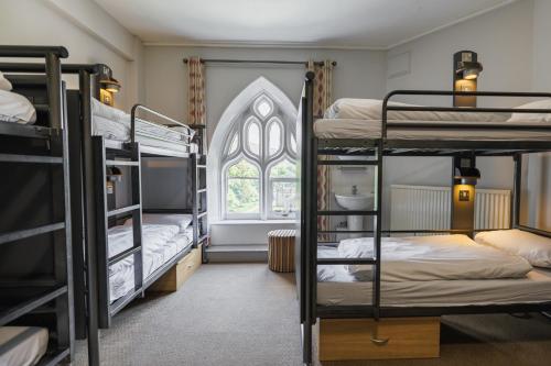 a dorm room with bunk beds and a window at YHA Ilam Hall in Ashbourne