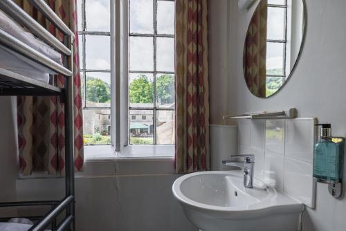 a bathroom with a sink and a mirror and a window at YHA Ilam Hall in Ashbourne
