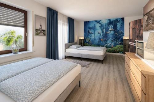 a bedroom with two beds and a painting on the wall at Whirlpool Kamin Sauna Herthasee in Eppenrod