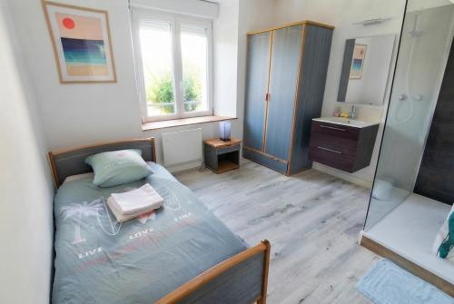 a bedroom with a bed and a sink and a mirror at Le tie-break in Pont-Croix