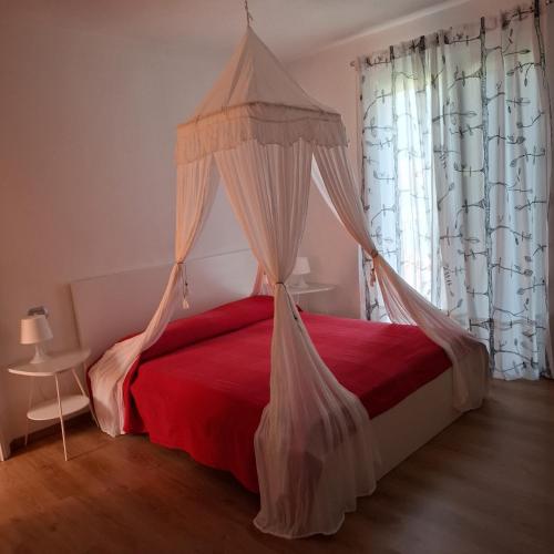 a bedroom with a red bed with a canopy at Casa Luce e Aria in Colico