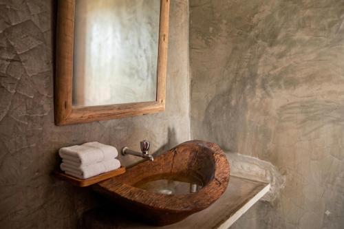 a bathroom with a wooden sink and a mirror at Pousada Villa Jodie in Fortim
