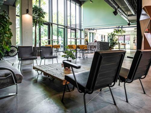 a room with chairs and a table in a building at Hotel Valkenburg by Mercure - Next to Shimano Experience Center in Valkenburg