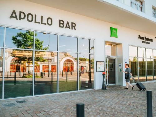 a woman walking in front of a store at ibis Styles Lens Centre Gare in Lens
