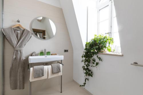 a bathroom with a sink and a mirror at Hôtel du Parc in Arles