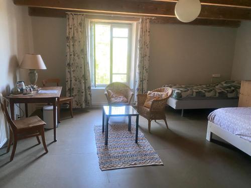 a bedroom with a bed and a table and chairs at Belmont-chambres 