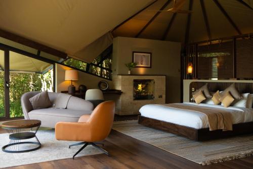 a bedroom with a large bed and a fireplace at Surana Mara Camp in Mara Simba
