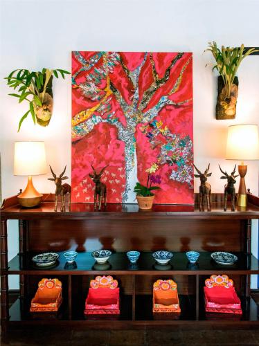 a painting of a tree on a wall above a shelf at Casas del XVI in Santo Domingo
