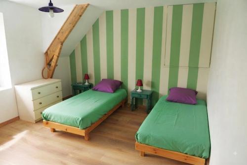 two beds in a room with green and purple at Le tie-break in Pont-Croix