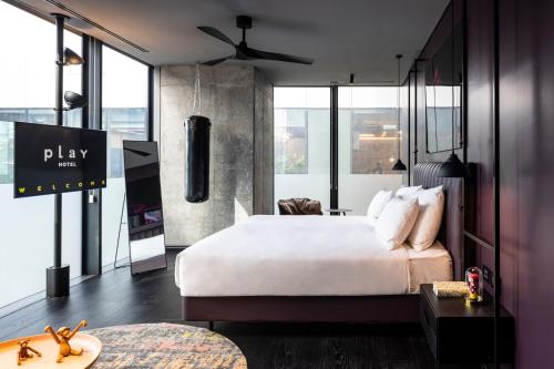 a hotel room with a large bed and a tv at Play Midtown Hotel Tel Aviv in Tel Aviv