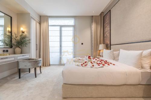 a bedroom with a large white bed and a desk at Amber Hospitality - Blvd in Riyadh