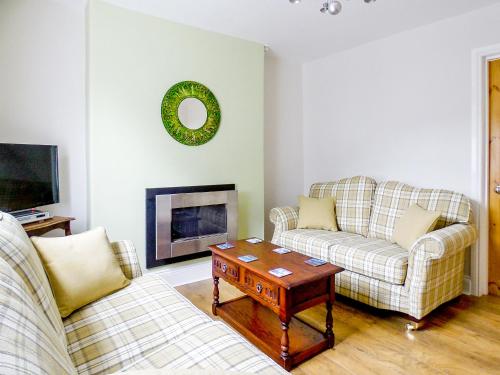 a living room with two couches and a coffee table at Ferndene Cottage in Hinderwell