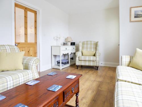 a living room with two couches and a coffee table at Ferndene Cottage in Hinderwell