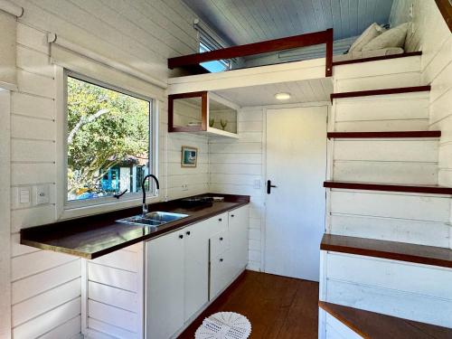 a small kitchen with a sink and a window at Peixe Crew Manguinhos in Búzios