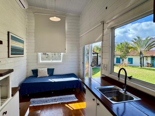 a tiny house with a sink and a window at Peixe Crew Manguinhos in Búzios