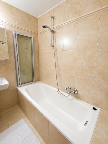 a bathroom with a bath tub and a sink at Haus am Anger Top 42 in Königsleiten