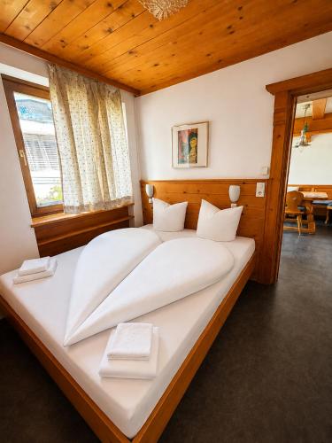 a bedroom with a large white bed with wooden ceilings at Haus am Anger Top 42 in Königsleiten