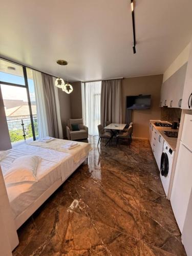a bedroom with a large bed and a kitchen at ,,KaKalo'' Apartments in Kobuleti