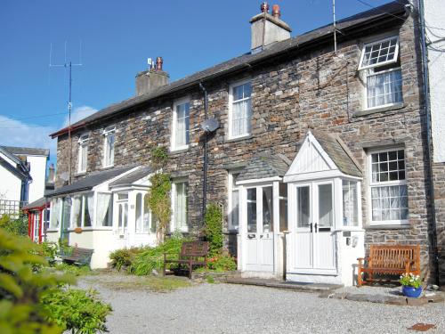 a brick house with a bench in front of it at 1 Tower Cottage in Portinscale