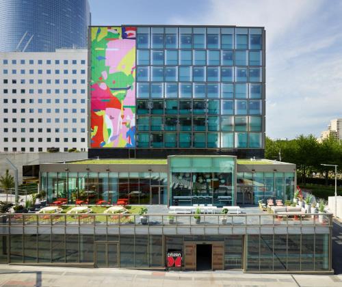 a large building with a lot of tables in front of it at citizenM Paris La Défense in Nanterre