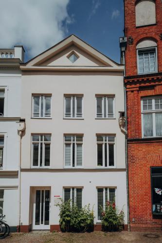 a white house with a brick building at Apartment Klara in Lübeck