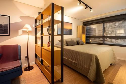 a bedroom with a bed and a book shelf at Studio 907 Flow Live - Parque Una + garagem in Pelotas