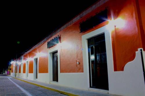 an orange and white building with a street at night at Hotel Hacienda Don Cenobio in San Pablo Villa de Mitla