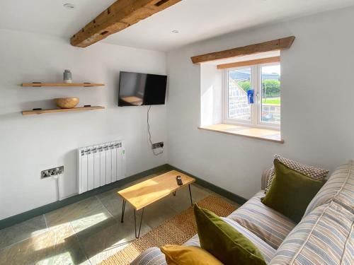 a living room with a couch and a table at The Cider Shed -Uk47420 in Curry Mallet