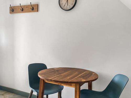 a table and two chairs and a clock on the wall at The Cider Shed -Uk47420 in Curry Mallet