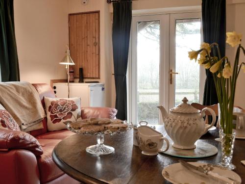 a living room with a table and a couch at Ty Newydd Cottage in Hoel-galed