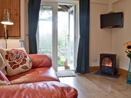 a living room with a couch and a fireplace at Ty Newydd Cottage in Hoel-galed