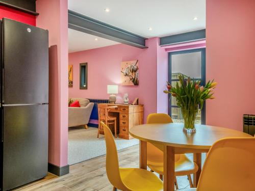 a kitchen and dining room with a table and a refrigerator at The Hideaway in Yarmouth